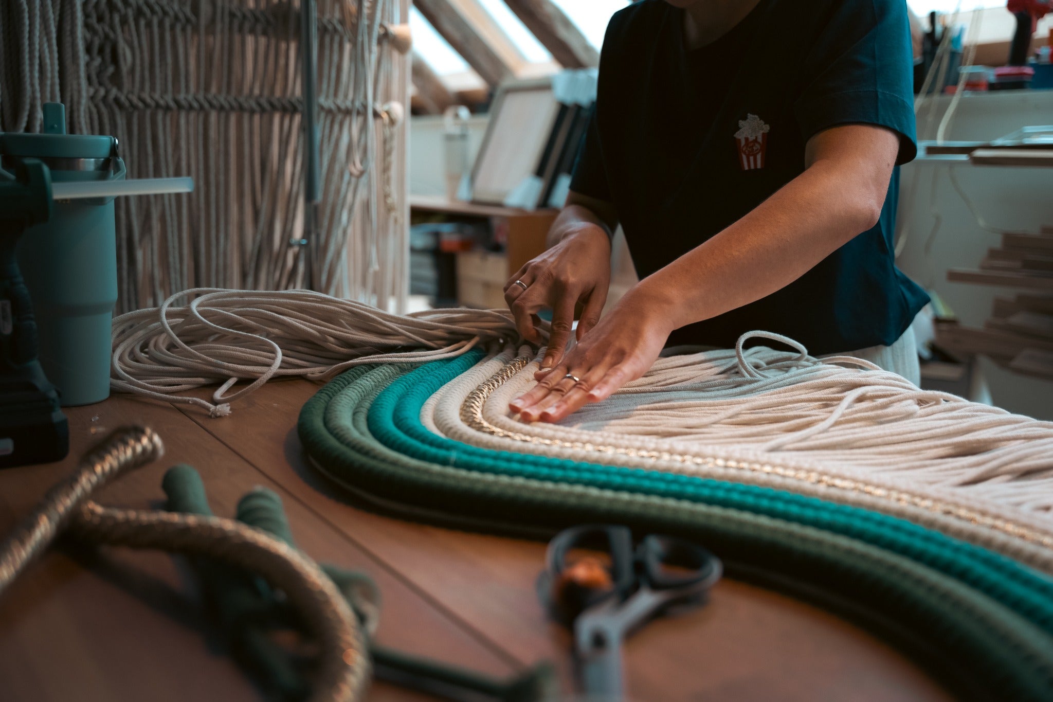 A textile artwork being assembled by hand in the studio